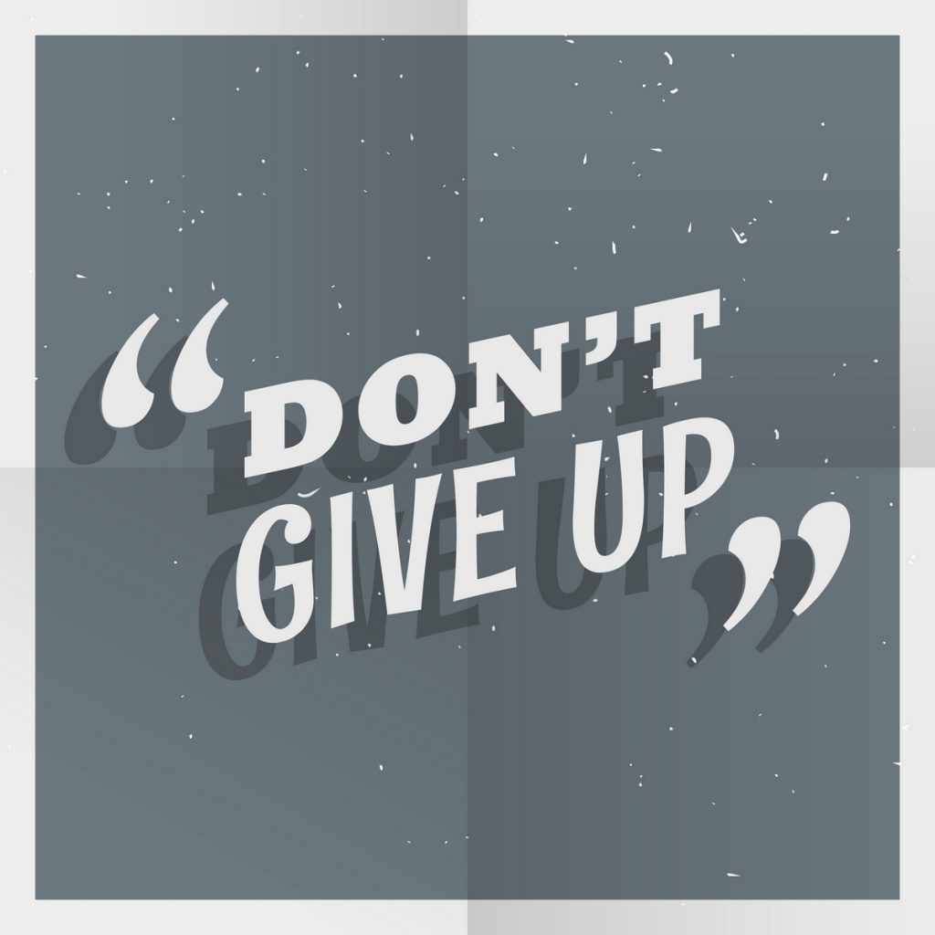 Papel com marcas de dobrado. Nele, está escrita a frase em inglês "don't give up".